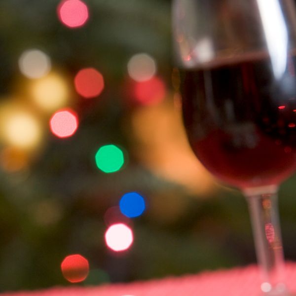 Glass of red wine with holiday lights in background