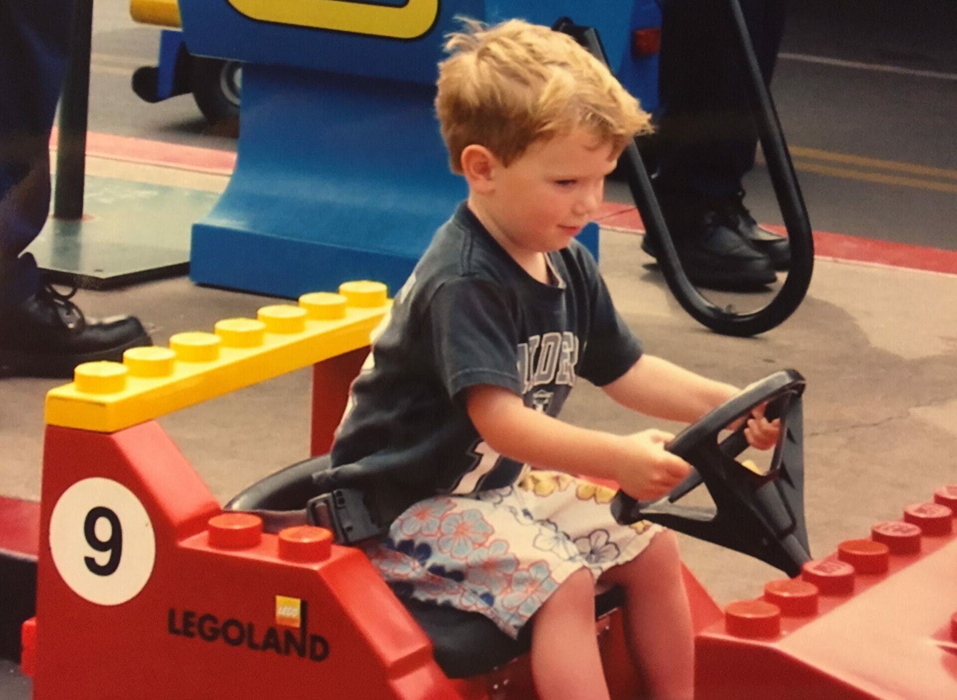 My son as a toddler carefully driving a small Lego car at Legoland
